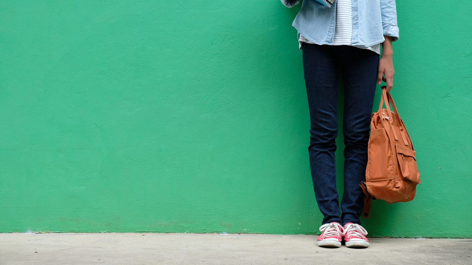 Student girl holding books and school bag